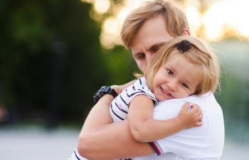 father holding a small girl in his arms