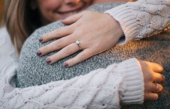 Woman embracing her fiancé, showing off her engagement ring