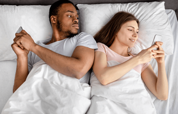 Couple in bed discussing social media and divorce