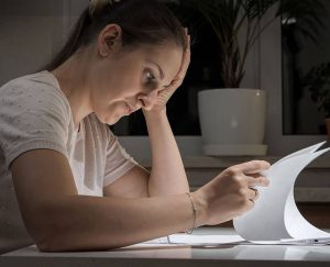 Woman looking at papers, wondering what is a default divorce