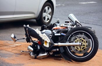 A car and a motorcycle lying on a side on a road after an accident Augusta, GA 