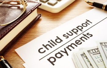 a calculator, banknotes and child support payments papers